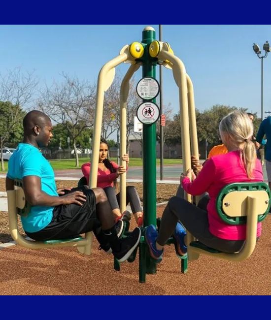 Fitness park equipment being used by adults for exercise.